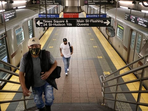 Commuters walk on a nearly empty subway platform in New York. 