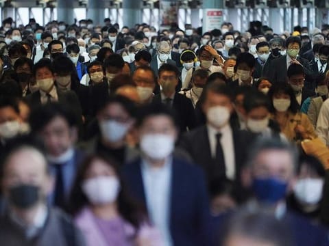 A station passageway is crowded with commuters wearing face masks to help curb the spread of the coronavirus during a rush hour in Tokyo Friday, Nov. 20, 2020.