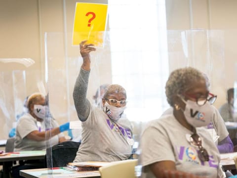 A Clayton County election worker holds up a sign signaling she needs help with determining a vote during a hand recount for the presidential election in Georgia last week. 