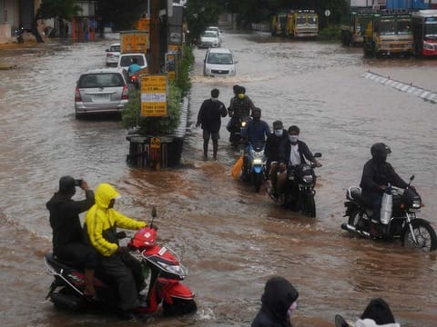 Motorists make their way along a waterlogged road after heavy rains following Cyclone Nivar landfall, in Puducherry on November 26, 2020.