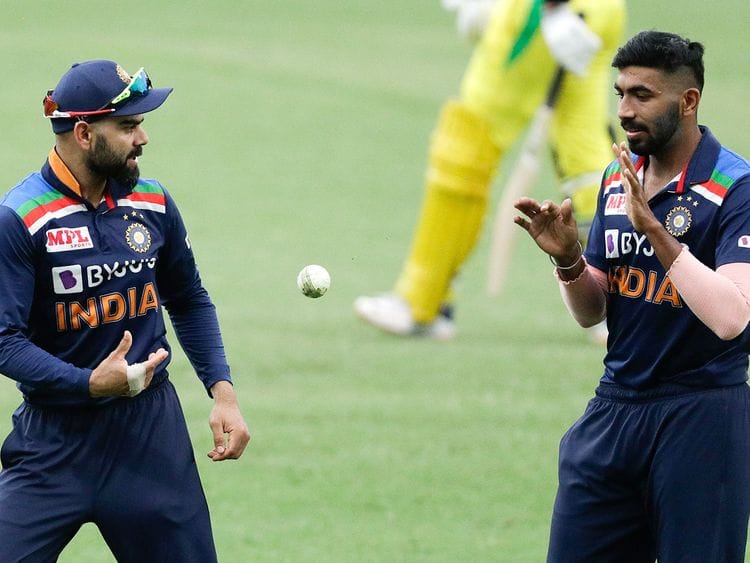 Virat Kohli passes the ball to teammate Jasprit Bumrah 