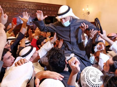 Kuwaiti candidate and former parliament speaker Marzouq Al Ghanem celebrates with his supporters following the announcement of his victory in parliamentary election in Kuwait city, on December 6, 2020. 