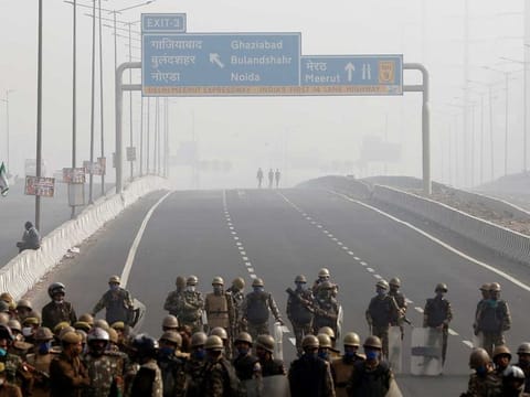 Police officers stand guard at the site of a protest on an empty blocked highway during a nationwide strike against the newly passed farm bills at the Delhi-Uttar Pradesh border in Ghaziabad, India, December 8, 2020. 