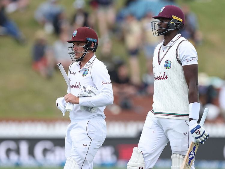 West Indies batsmen Jason Holder (R) and Joshua Da Silva leave the field as bad light stops play on day three of the second cricket Test match between New Zealand and the West Indies