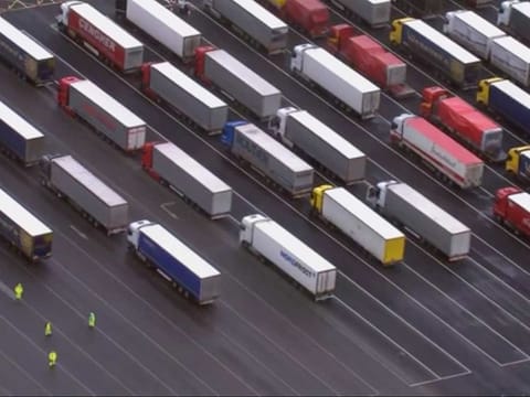 Trucks are parked in a holding area, in this aerial photo taken from video, lined up at former airfield in Manston, England, close to the M20 highway that runs to the port of Dover, Britain's main ferry connection with mainland Europe in northern France, Tuesday Dec. 22, 2020. The goods trucks are waiting to get out of Britain as France barred travel from the UK for 48 hours because of a new and seemingly more contagious strain of the coronavirus in England.