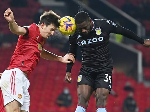Manchester United's English defender Harry Maguire (L) vies with Aston Villa's English striker Keinan Davis (R) during the match at Old Trafford in Manchester. 