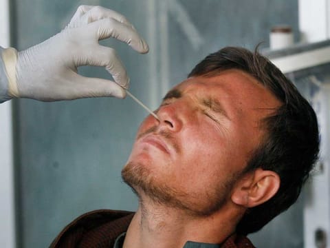 A health care worker takes a nasal swab sample [File image used for illustrative purposes]