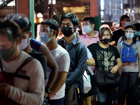In 2020, hacking and other malware attacks surged by a whopping 2,324% from the previous year, while phishing and other social engineering schemes increased 302% from 2019, according to the Philippine central bank. File photo shows people wearing face masks and face shields as protection against the coronavirus disease (COVID-19) queue at a bus stop, in Quezon City, Metro Manila, Philippines.