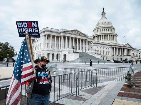  A counter-protester in holding a sign in support of President-elect Joe Biden and vice-president-elect Kamala Harris stands before Capitol Building on January 6, 2021 in Washington, DC. 