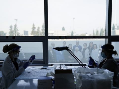 Health care workers prepare the Pfizer-BioNTech COVID-19 vaccine for medical workers at a hospital in Orange, California. 