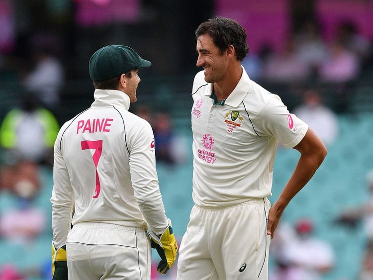 Australia's captain Tim Paine (L) speaks with Australia's Mitchell Starc 