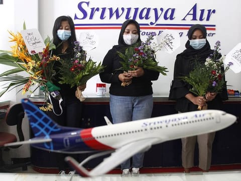 Women pray for passengers of Sriwijaya Air's flight SJ182, which crashed into the sea off the Jakarta coast, in Solo, Central Java Province, Indonesia.