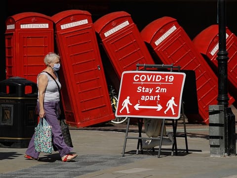 File photo: A sign requesting people stay two metres apart to try to reduce the spread of COVID-19 is displayed in front of "Out of Order" a 1989 red phone box sculpture by British artist David Mach, in London.  