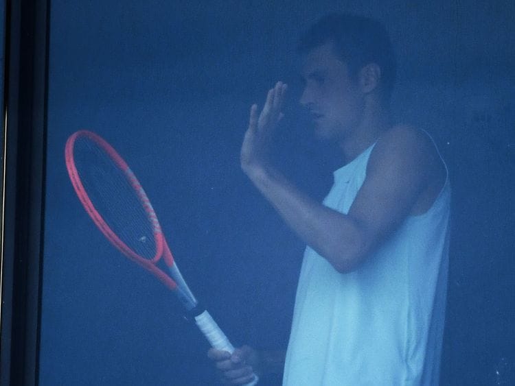 Bernard Tomic is pictured at his hotel room window