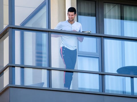 Serbia's Novak Djokovic stands on the balcony at his accommodation in Adelaide, Australia.