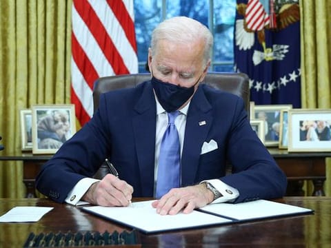 U.S. President Joe Biden signs executive orders in the Oval Office of the White House in Washington, after his inauguration as the 46th President of the United States, U.S., January 20, 2021.