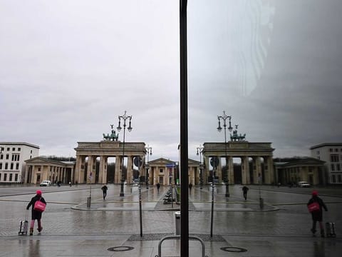 The near-empty Pariser Platz square in front of Berlin's landmark Brandenburg Gate (Brandenburger Tor) is reflected in a shop window on January 22, 2021, during the ongoing novel coronavirus (COVID-19) pandemic. 