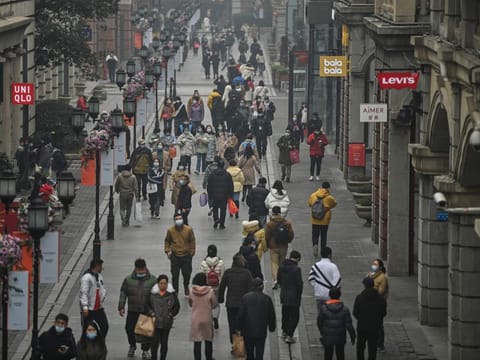People walk along a pedestrian street in Wuhan, China's central Hubei province on January 23, 2021, one year after the city went into lockdown to curb the spread of coronavirus.