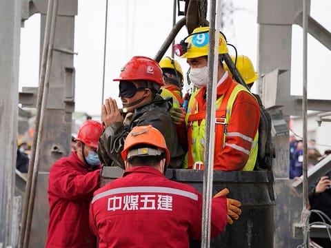 One of twenty-two Chinese miners wearing a black patch is saved from hundreds of metres underground, where they had been trapped for two weeks after a gold mine explosion in Qixia, in eastern China's Shandong province. 