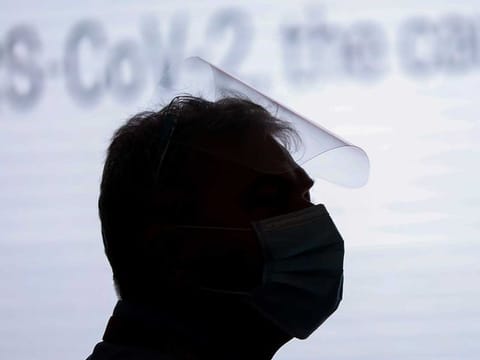 A man wearing a face mask and face shield 