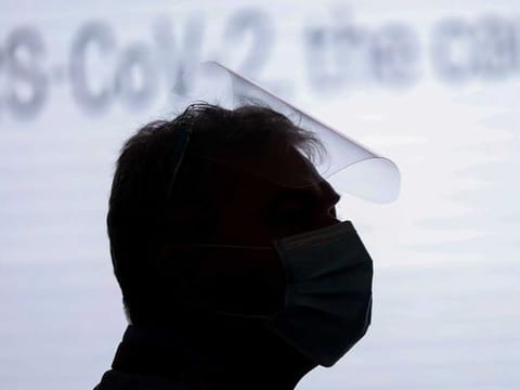 A man wearing a face mask and face shield 