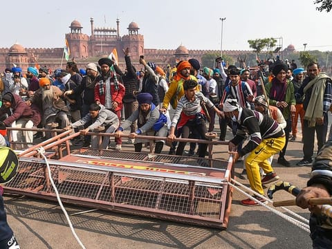 Farmers remove police barricades set up near the Red Fort during the 'Kisan Gantantra Parade' amid the 72nd Republic Day celebrations, in New Delhi, Tuesday, Jan. 26,  2021.