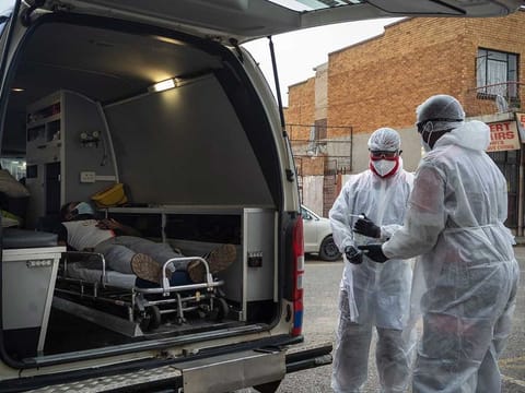 Paramedics Michael Makhethe, right, and Clive Moleso working from the Saaberie Chishty ambulance service, transfer a COVID-19 patient to the hospital in Lenasia, South Africa, Thursday, Jan. 7, 2021. 