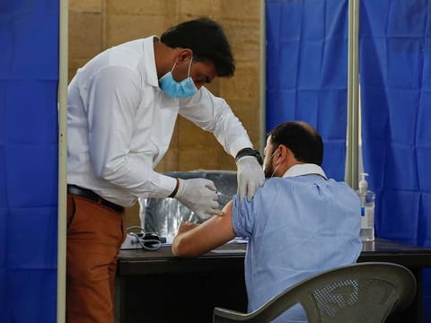 A health worker receives a dose of Sinopharm's coronavirus disease (COVID-19) vaccine, donated by China, at a vaccination centre in Karachi, Pakistan February 8, 2021. 