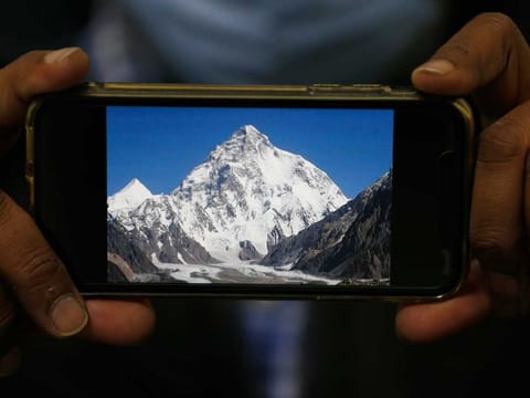 A photo of K2, the world's second-highest mountain, is displayed on a cell phone in Islamabad, Pakistan, Tuesday, Feb. 9, 2021.