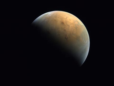 EMM captured the largest volcano in the solar system, Olympus Mons (centre), emerging into the early morning sunlight.
