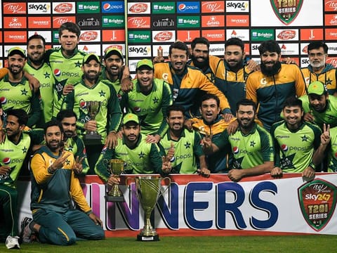 Pakistan's players and team officials pose for photographs with the trophy after winning the T20 series against South Africa at the Gaddafi Cricket Stadium in Lahore on February 14, 2021. 