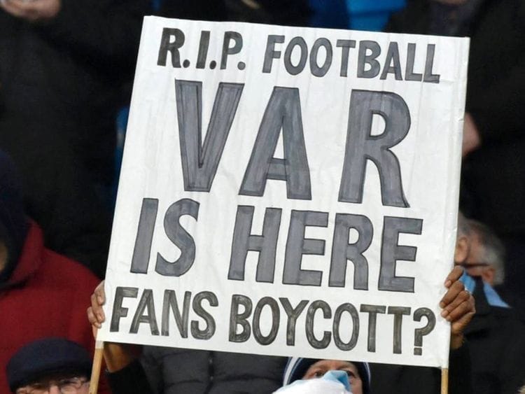 Fans hold up signs protesting against VAR.
