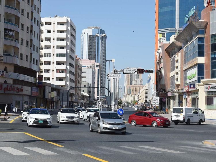 Stock Ajman skyline taxi bus street