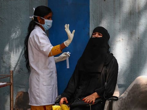 A health worker prepares to collect a nasal swab sample at a COVID-19 testing centre in Hyderabad, India, Tuesday, Feb. 23, 2021. 