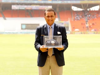 Sunil Gavaskar poses for the photographers with a 'blue baggy' cap, presented to him on the 50th anniversary of his memorable Test debut, by BCCI during Ahmedabad Test.