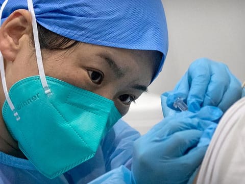 A medical worker gives a coronavirus vaccine shot to a patient at a vaccination facility in Beijing. 