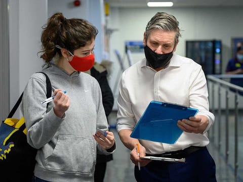 Labour Party leader Keir Starmer assists with checking in patients who have arrived for their second COVID-19 vaccination during a visit to the Whittington Hospital in London, Britain March 15, 2021.