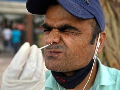 A health worker collects a swab sample from a man for a coronavirus test in New Delhi, India, on March 23, 2021. 