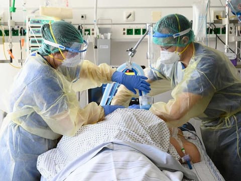 Medical staff take care of a COVID-19 patient in the COVID-19 intensive care unit of the Robert Bosch hospital in Stuttgart, southern Germany, on March 24, 2021, amid the novel coronavirus pandemic. 