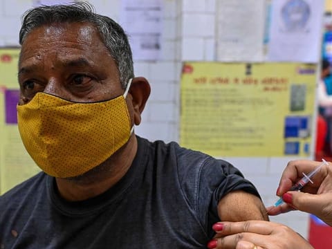 A medical worker inoculates a man with the Covaxin COVID-19 coronavirus vaccine at a health centre in New Delhi on March 25, 2021.