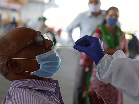 A health worker takes a nasal swab sample to test for COVID-19 in Ahmedabad, India, Friday, March 26, 2021. 