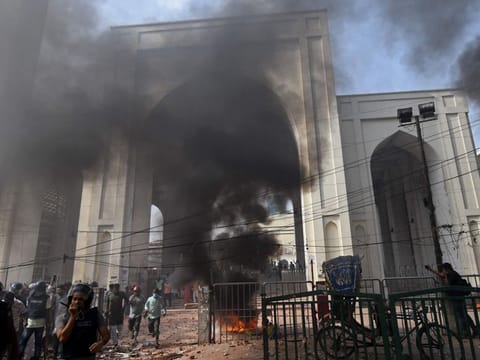 Activists from Islamist groups set a motorcycle on fire during a clash with the police as they protest against the visit of Indian Prime Minister Modi in Dhaka on March 26, 2021. 