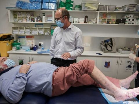 Rob Courtney, a Buruli ulcer patient, being treated in March 2021 in Sorrento, Australia, by Dr Daniel O’Brien and Donna Beckett, a nurse. The disease is caused by a species of flesh-eating bacteria. 