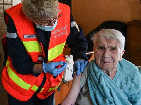 Maria, 93, receives a dose of the Pfizer/BioNTech COVID-19 vaccine by a fire-fighting nurse at her home in Saint-Bonnet-en-Champsaur, southeastern France, on March 30, 2021.