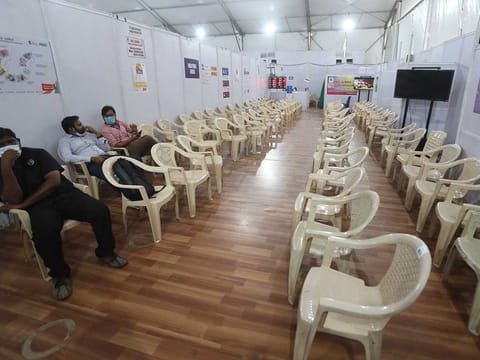 Health workers sit in the waiting area of vaccination centre which has been closed because of shortage of the COVID-19 vaccine in Mumbai, India, Tuesday, April 20, 2021. 