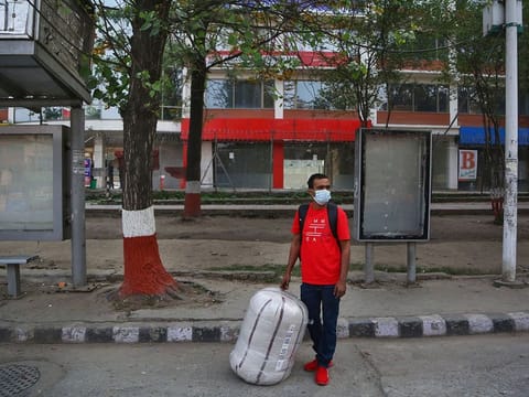 A Nepalese migrant worker who arrived from Saudi Arabia waits for a hitchhike to go back to his village during the first day of lockdown in Kathmandu, Nepal, Thursday, April 29, 2021.