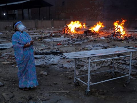 A woman cries during the cremation of her husband, who died from the coronavirus disease (COVID-19), at a crematorium in New Delhi, India May 5, 2021. 