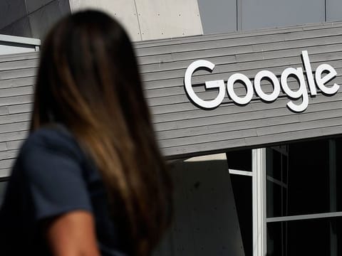 A woman walks below a Google sign on the campus in Mountain View, California. 