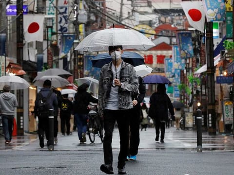 A man wearing a protective face mask, amid the coronavirus disease (COVID-19) pandemic, makes his way at a local shopping street in Tokyo, Japan, May 5, 2021. 