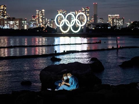  A couple pose for pictures before the lit Olympic rings at the Odaiba waterfront in Tokyo on May 6, 2021.